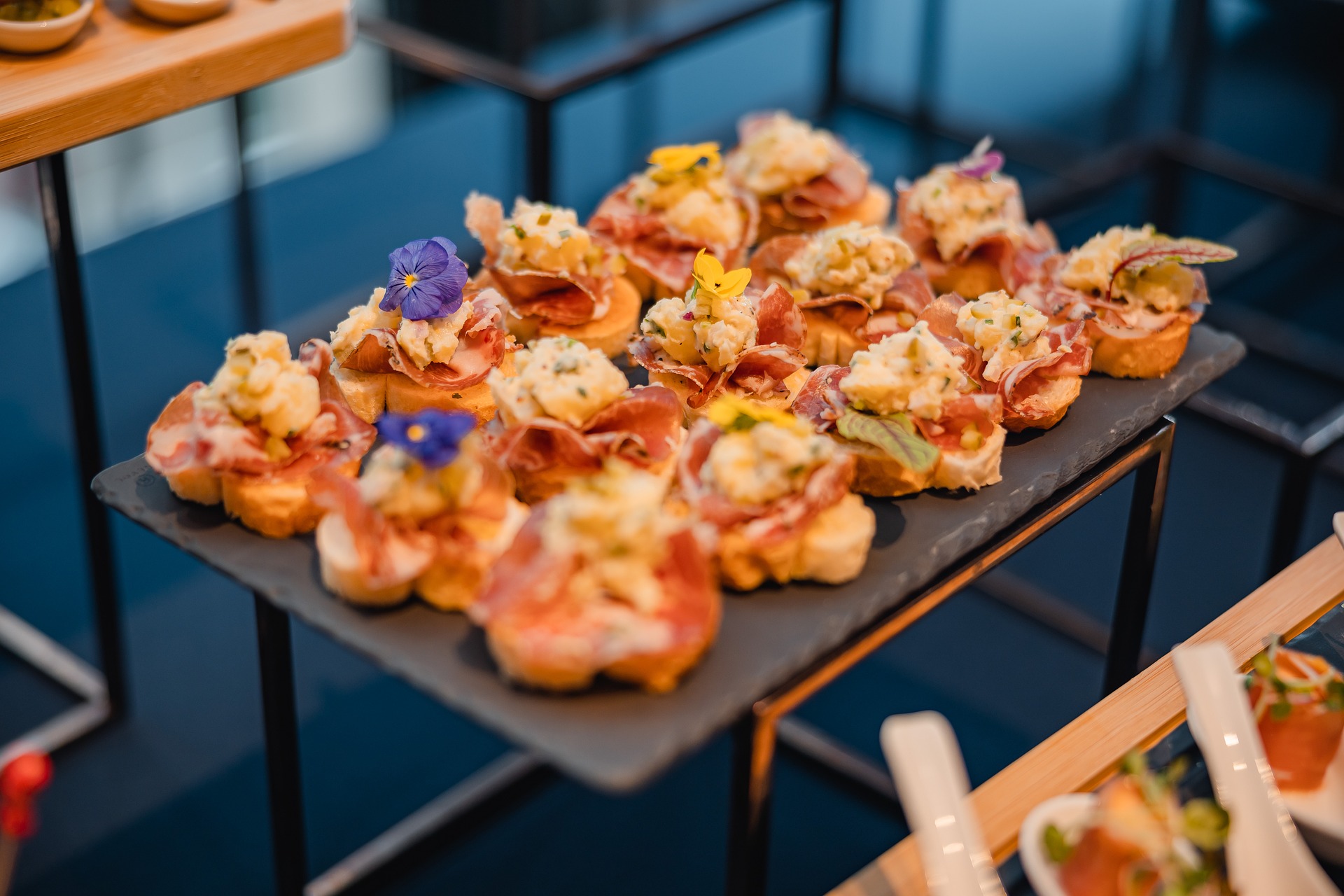Elegante Canapés mit Prosciutto und essbaren Blüten